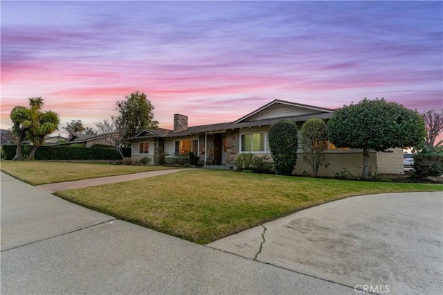 single story home featuring a lawn