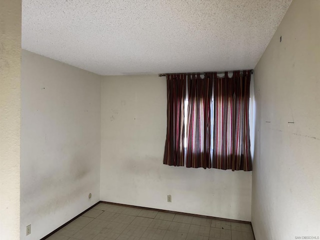 unfurnished room featuring a textured ceiling