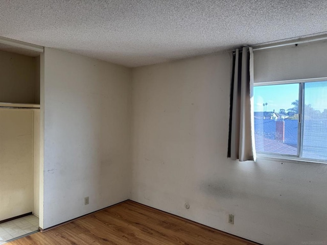 unfurnished bedroom with light hardwood / wood-style floors and a textured ceiling