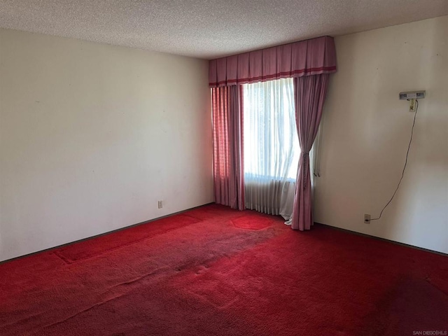 carpeted spare room featuring a textured ceiling