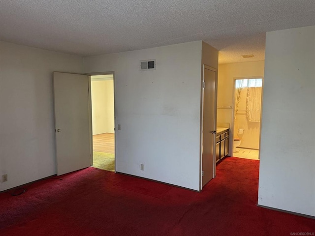 carpeted spare room featuring a textured ceiling