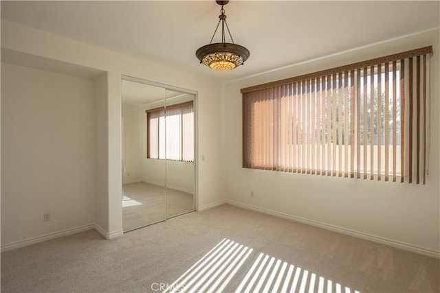 unfurnished bedroom featuring light colored carpet and a closet