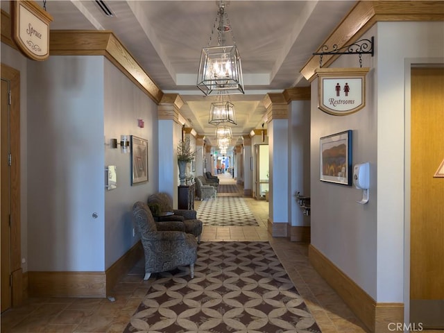 corridor featuring an inviting chandelier, tile patterned floors, and a raised ceiling