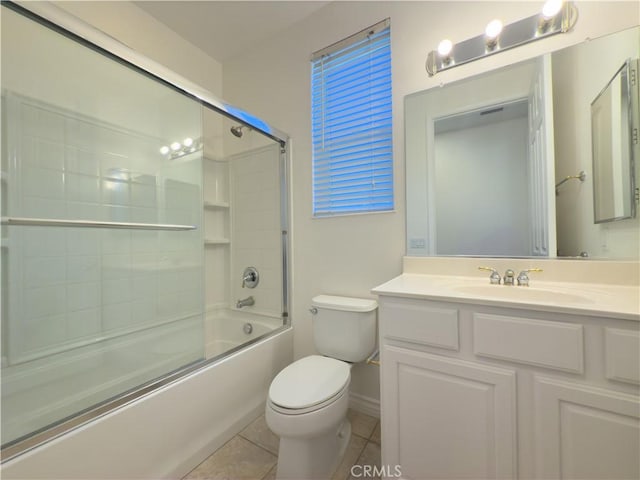 full bathroom featuring toilet, tile patterned floors, bath / shower combo with glass door, and vanity