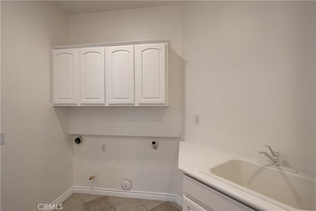 clothes washing area with sink, hookup for a gas dryer, cabinets, light tile patterned floors, and electric dryer hookup