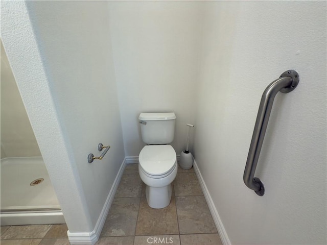 bathroom with tile patterned flooring, a shower, and toilet