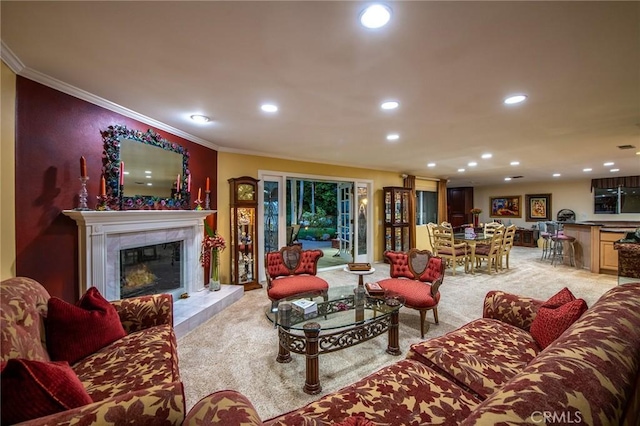 living room featuring a tiled fireplace, ornamental molding, and light colored carpet