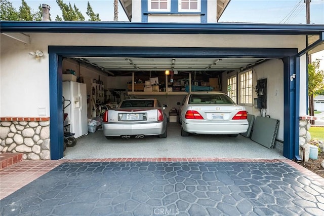 garage featuring white refrigerator with ice dispenser