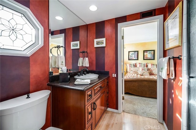 bathroom featuring wood-type flooring, toilet, and vanity