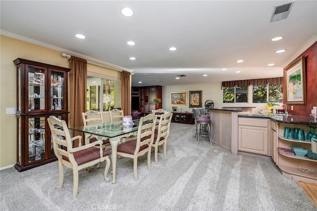 dining room with crown molding, light colored carpet, sink, and a wealth of natural light