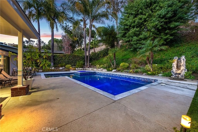 pool at dusk with a patio