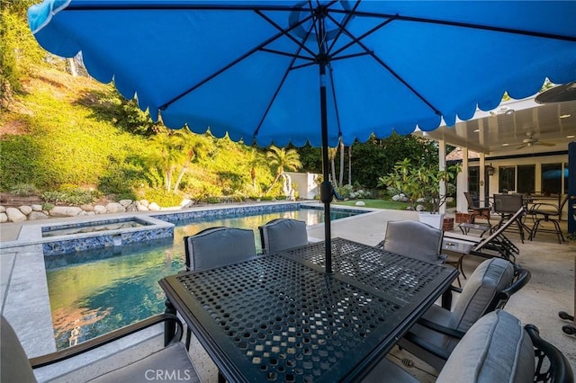 view of patio / terrace featuring ceiling fan and a pool with hot tub