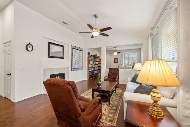 living room featuring ceiling fan, lofted ceiling, a fireplace, and dark hardwood / wood-style flooring