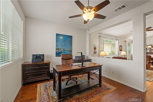 home office with dark hardwood / wood-style flooring and ceiling fan