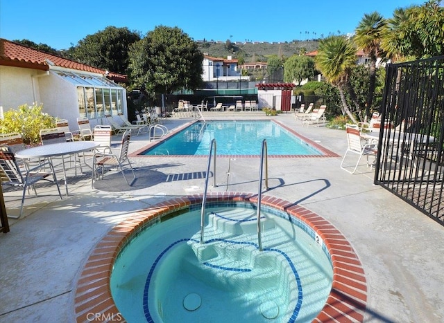 view of pool featuring a patio area and a hot tub