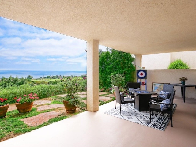 view of patio featuring a water view and an outdoor fire pit