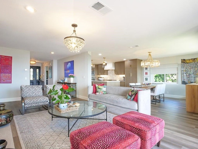 living room with a chandelier and light wood-type flooring