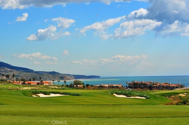 view of home's community featuring golf course view, a yard, and a water view