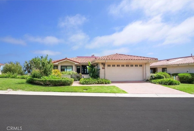 mediterranean / spanish home with a garage and a front lawn