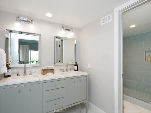 bathroom with vanity and tiled shower