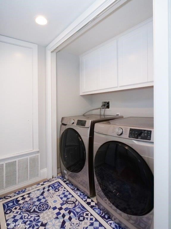 laundry area featuring washer and clothes dryer and cabinets