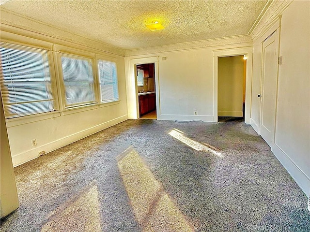 unfurnished room featuring ornamental molding, a textured ceiling, and carpet