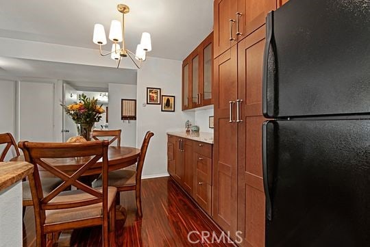 dining space with dark wood-type flooring and a chandelier