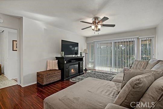 living room featuring dark wood-type flooring and ceiling fan