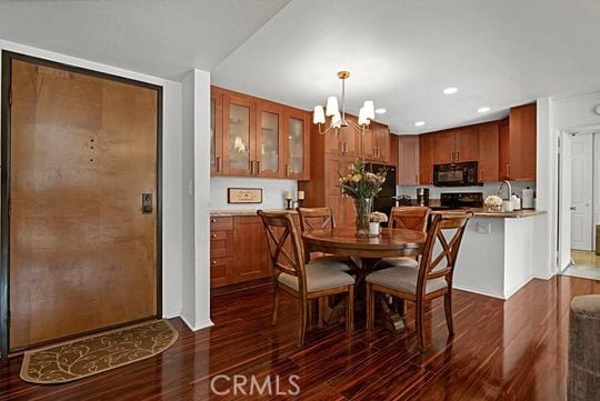 dining area with dark hardwood / wood-style floors and a chandelier