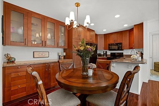 dining space with sink, a chandelier, and dark hardwood / wood-style flooring