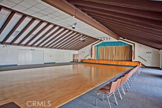 playroom featuring vaulted ceiling with beams, hardwood / wood-style floors, and ceiling fan