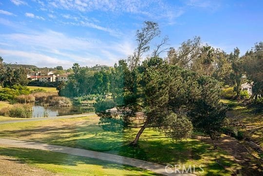 view of community featuring a water view and a lawn