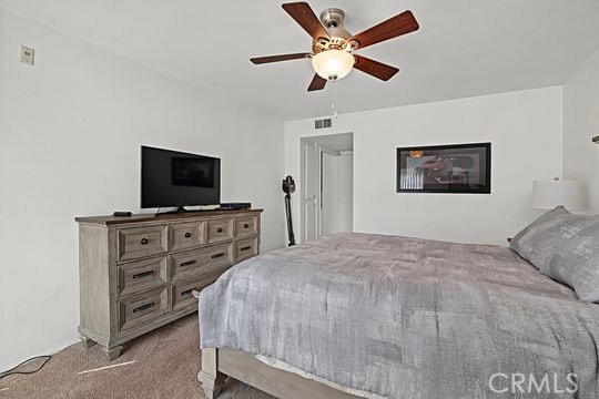 bedroom featuring ceiling fan and light carpet