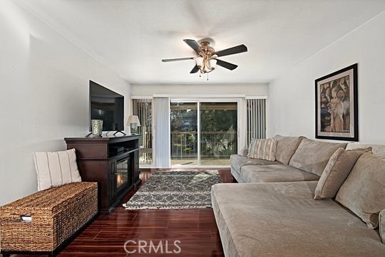 living room with dark hardwood / wood-style floors and ceiling fan