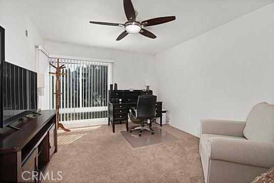 home office featuring light carpet and ceiling fan