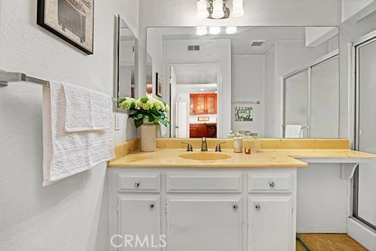 bathroom with vanity and a shower with shower door