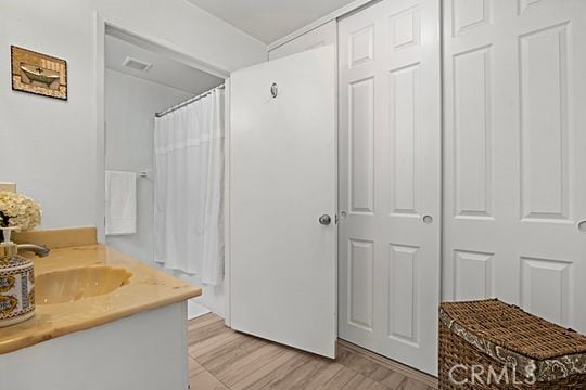 bathroom featuring vanity, wood-type flooring, and walk in shower