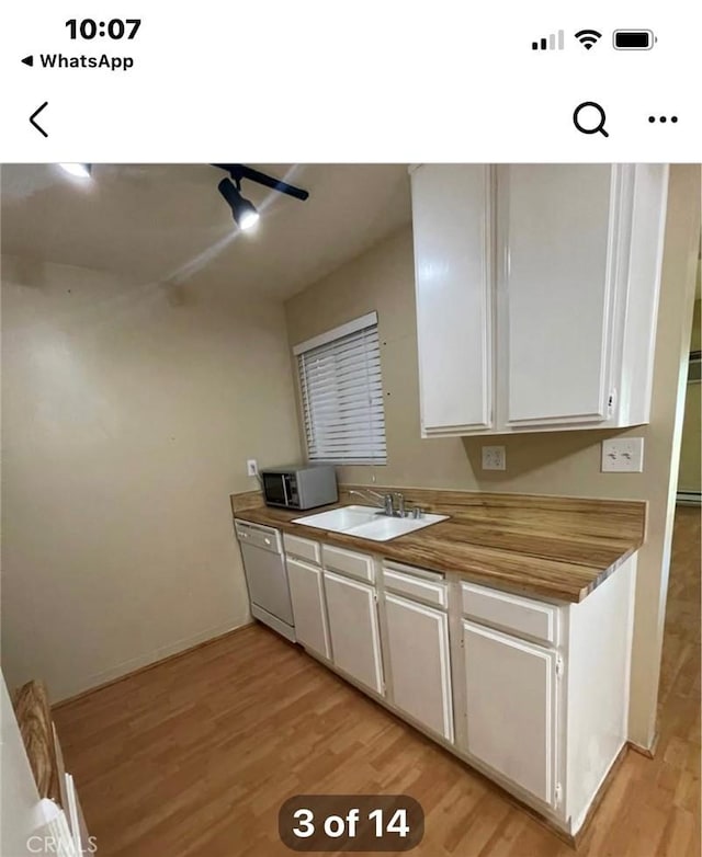 kitchen featuring white cabinetry, light hardwood / wood-style floors, dishwasher, and sink