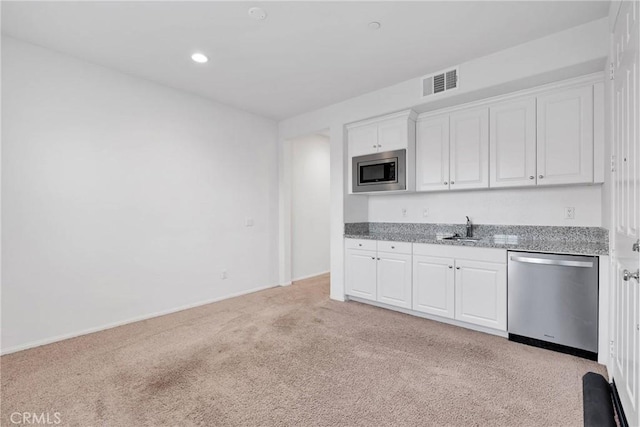 kitchen featuring sink, white cabinets, light colored carpet, stainless steel appliances, and light stone countertops