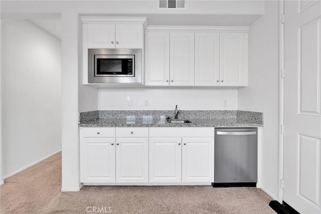 kitchen featuring light stone counters, stainless steel appliances, sink, and white cabinets