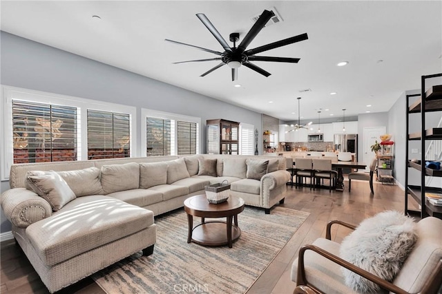 living room with ceiling fan and light hardwood / wood-style flooring