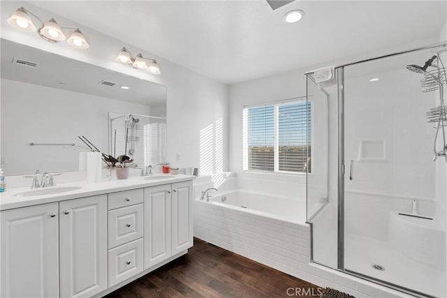 bathroom with vanity, hardwood / wood-style flooring, and plus walk in shower