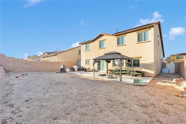 back of property featuring a gazebo and a patio area