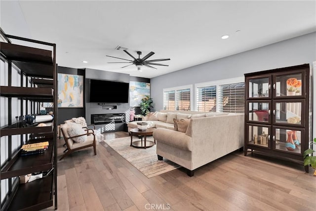 living room featuring wood-type flooring and ceiling fan