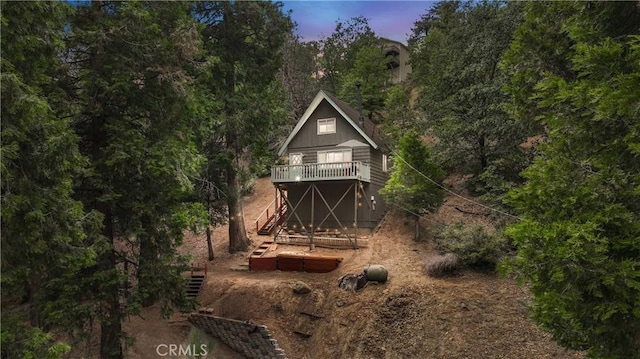 back house at dusk featuring a wooden deck