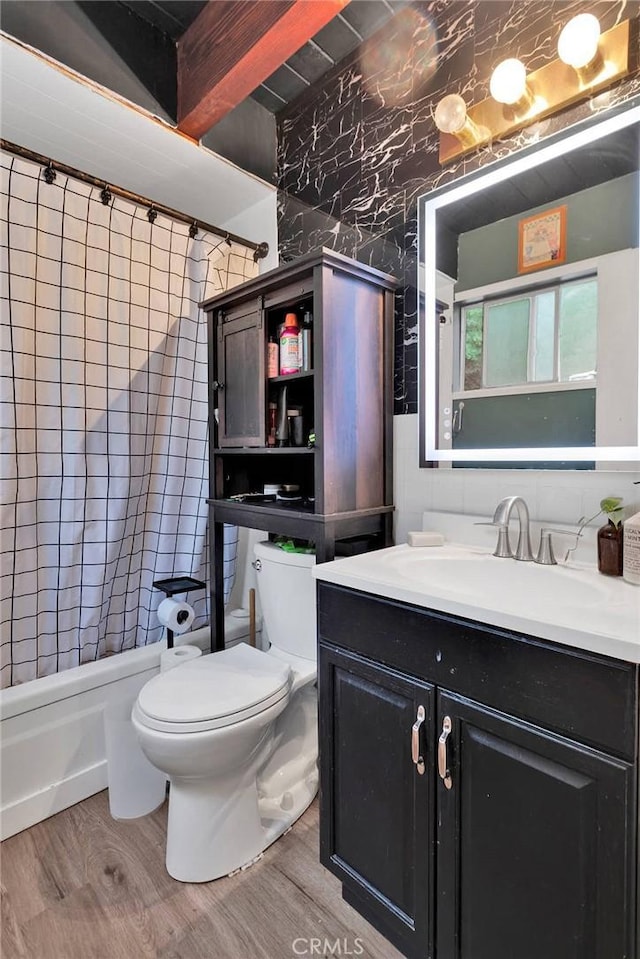 full bathroom with hardwood / wood-style flooring, vanity, shower / tub combo with curtain, and toilet