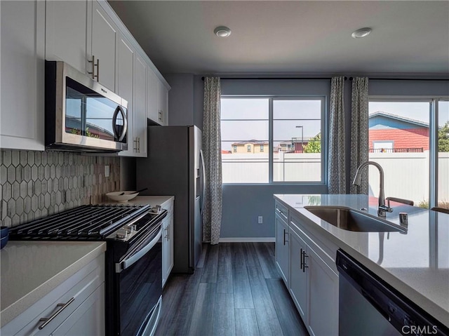 kitchen with stainless steel appliances, sink, decorative backsplash, and white cabinets