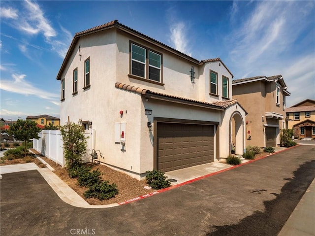 mediterranean / spanish home featuring a garage