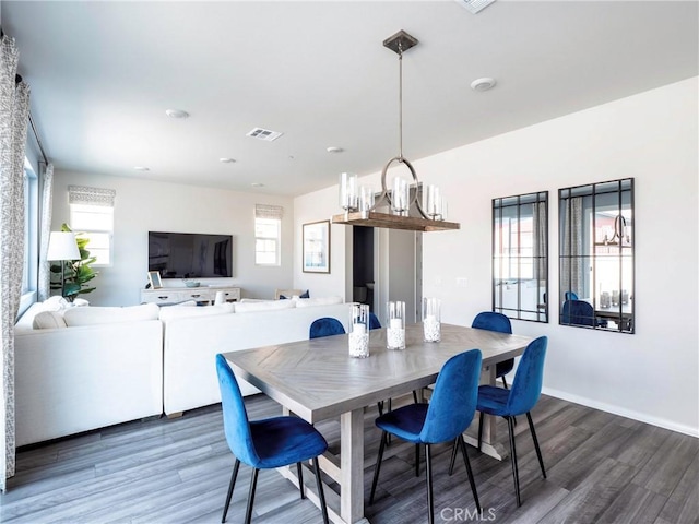 dining area featuring a chandelier, dark hardwood / wood-style floors, and a healthy amount of sunlight