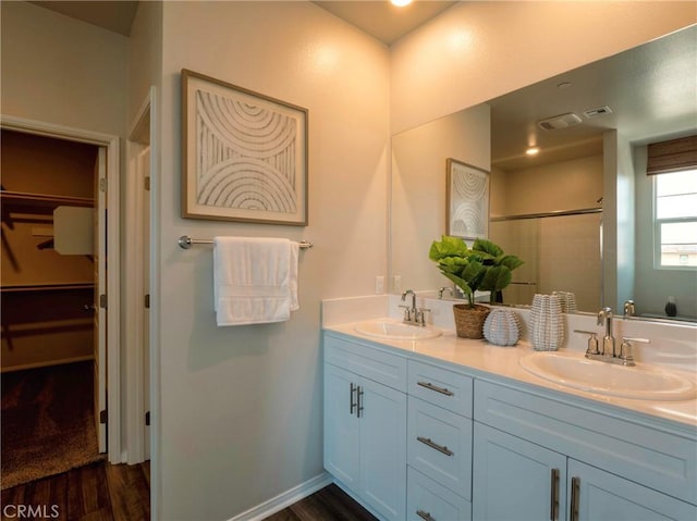 bathroom with vanity, hardwood / wood-style flooring, and a shower with door